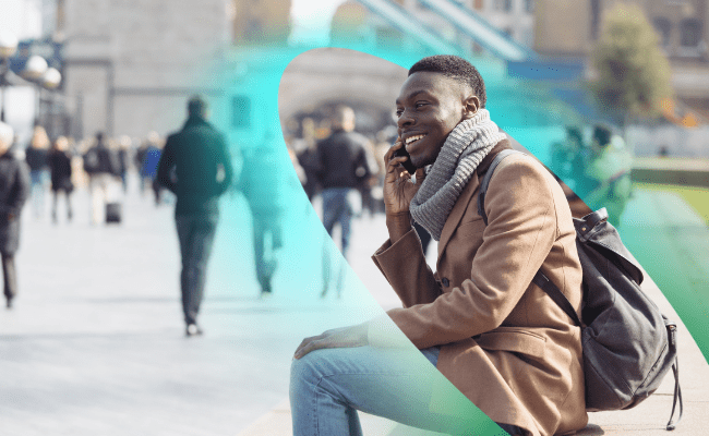 A man uses a mobile phone outdoors in an open environment thanks to outdoor small cells in the area.