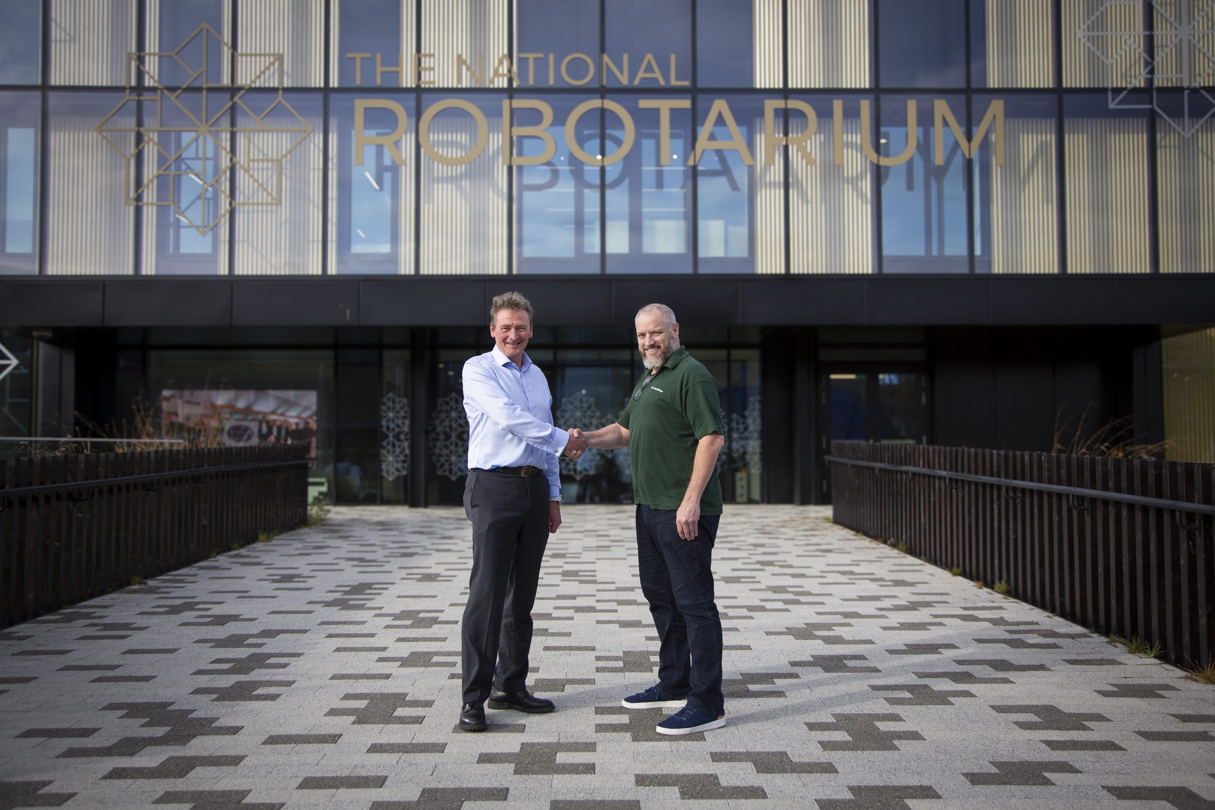 Steve Maclaren COO at the National Robotarium and Tom Bennett CTO at Freshwave shake hands in front of the National Robotarium