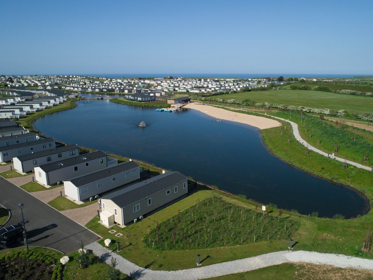 Lake surrounded by grass and caravans